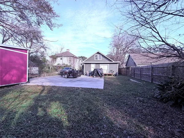 a view of a house with a yard and a large tree