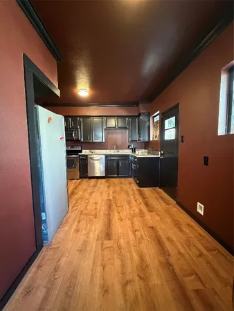 a open kitchen with stainless steel appliances granite countertop a refrigerator and a stove top oven