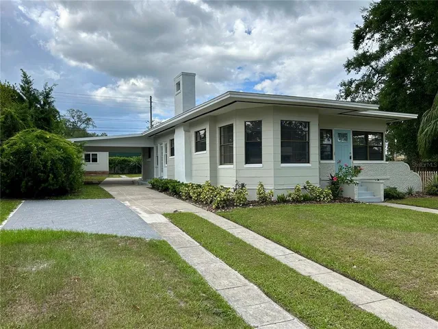 a front view of a house with a garden and yard
