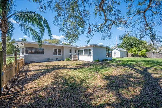 a view of a house with backyard and tree