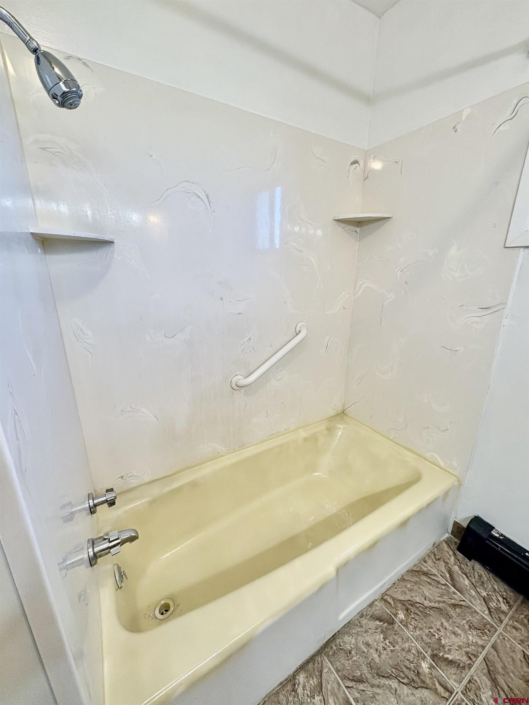 1738 East 7th Street Delta, CO 81416 - Photo 26 of 38 a bathroom with a tub and a shower