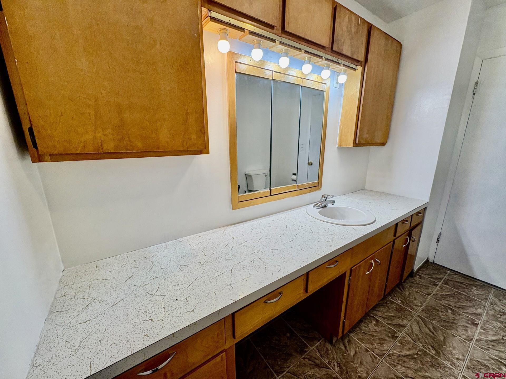 1738 East 7th Street Delta, CO 81416 - Photo 27 of 38 a bathroom with a sink and a mirror