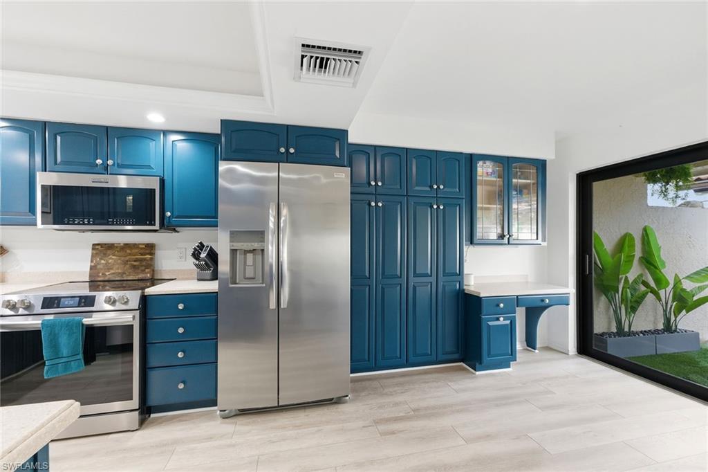 646 Augusta Boulevard Naples, FL 34113 - Photo 14 of 43 a kitchen with a refrigerator and a sink