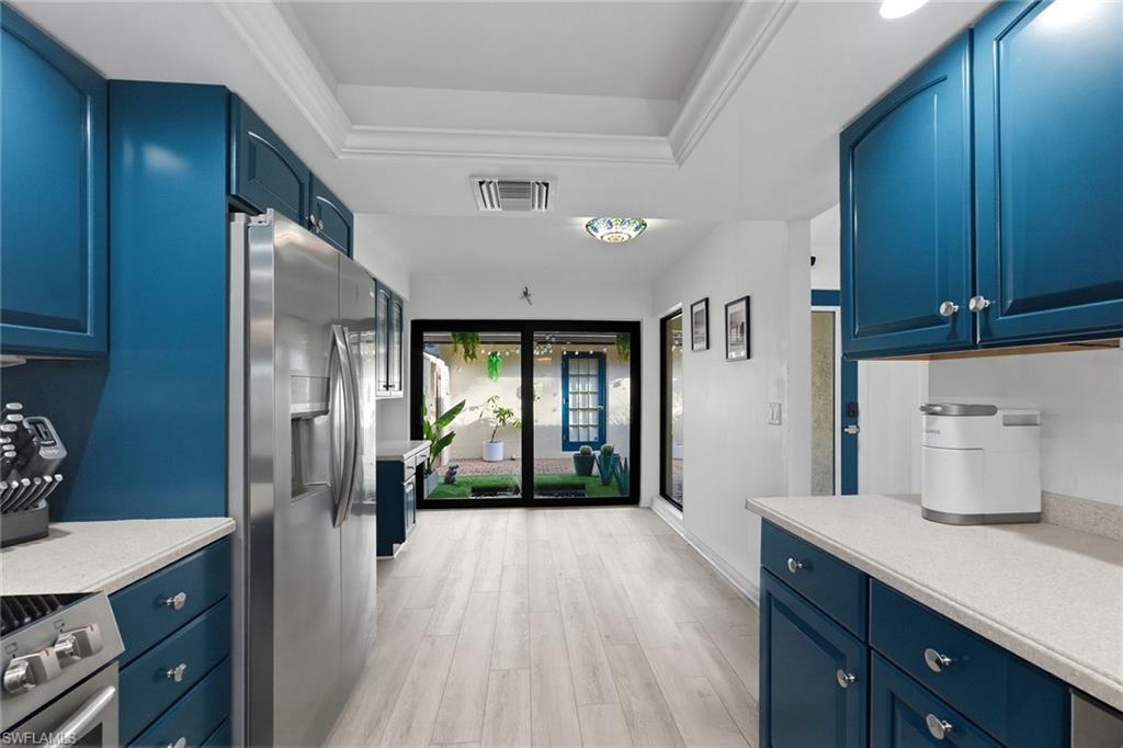 646 Augusta Boulevard Naples, FL 34113 - Photo 17 of 43 a kitchen with a refrigerator and wooden floor