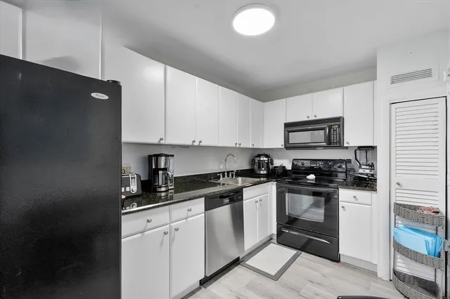 a kitchen with stainless steel appliances granite countertop a stove a sink and a refrigerator