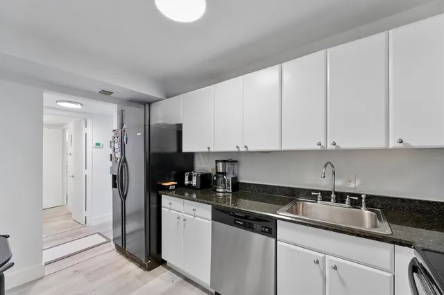 a kitchen with stainless steel appliances granite countertop a sink a refrigerator and a granite counter tops