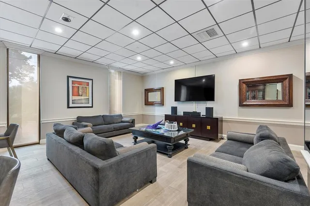a living room with furniture a flat screen tv and a large window