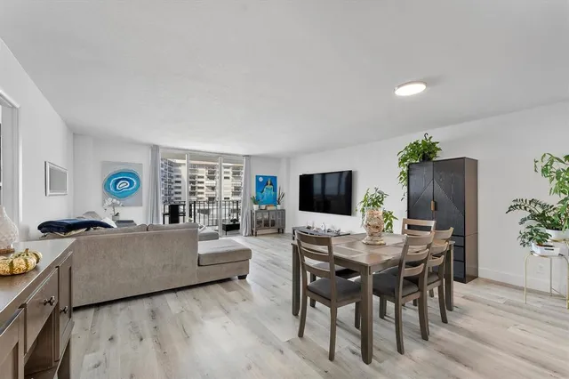 a living room with furniture a flat screen tv and a large window