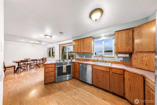 a large kitchen with stainless steel appliances granite countertop a sink and cabinets