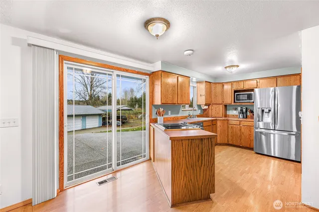 a kitchen with a refrigerator and a stove top oven