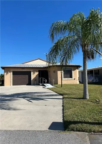 a house with a yard and palm trees