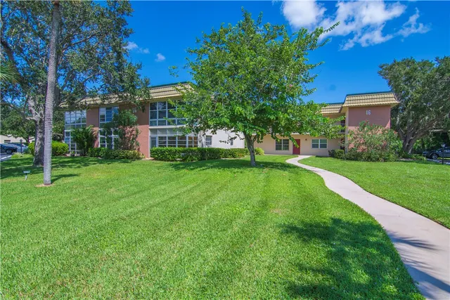 a view of a house with a big yard and large trees