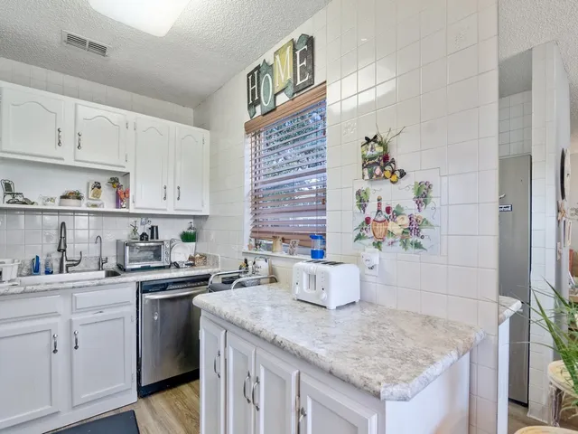 a kitchen with stainless steel appliances a sink a stove and cabinets