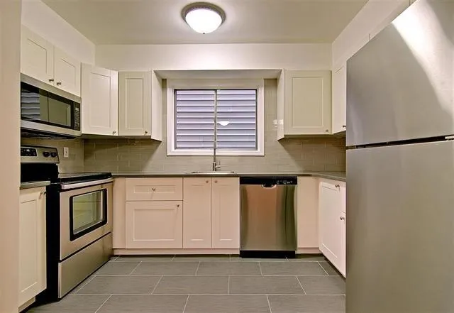 a kitchen with stainless steel appliances granite countertop a refrigerator sink and stove