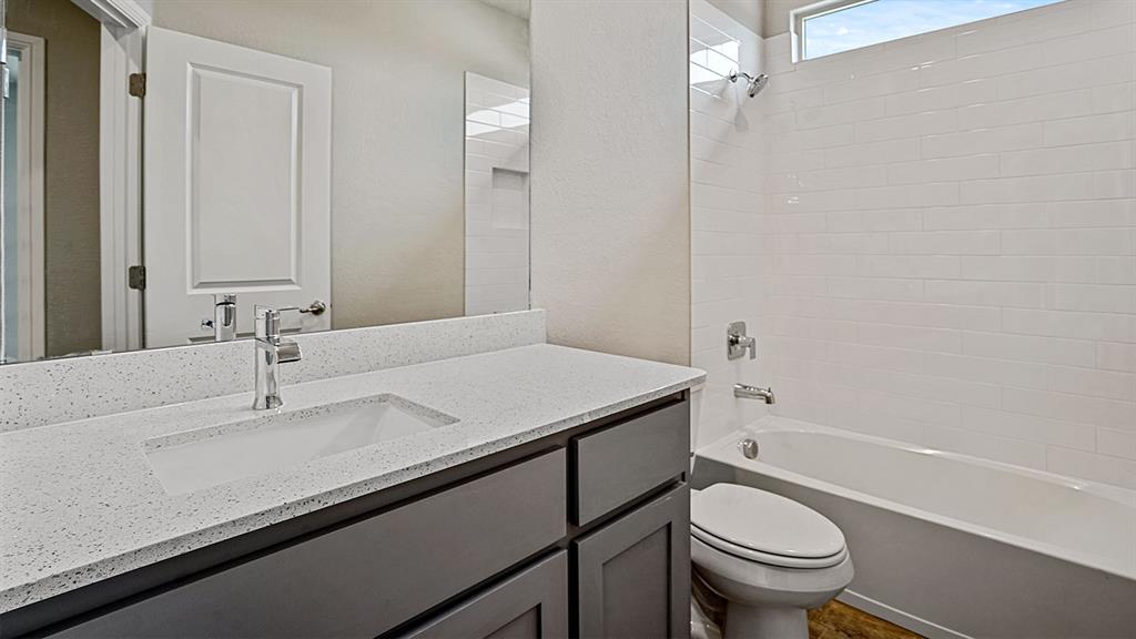 14517 Caelum Drive Haslet, TX 76052 - Photo 13 of 18 a bathroom with a sink toilet vanity and shower