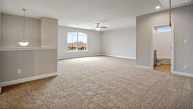 en empty room with windows and ceiling fan