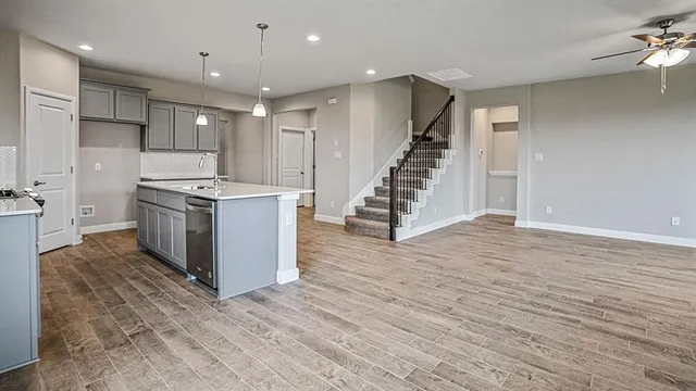 a kitchen with stainless steel appliances a stove top oven a sink and a refrigerator