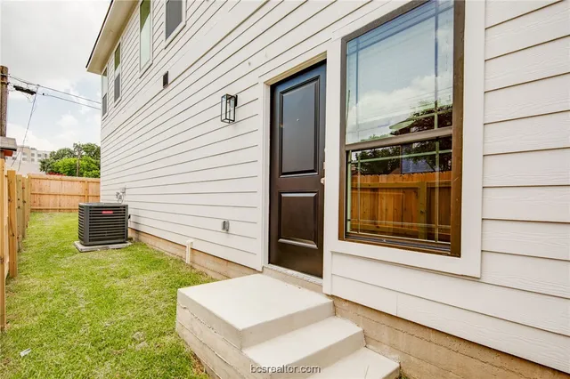 a view of front door and a yard