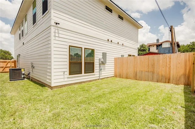 a view of a white house with a backyard
