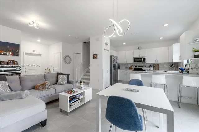 a living room with furniture and kitchen view