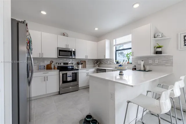 a kitchen with a sink stainless steel appliances and white cabinets
