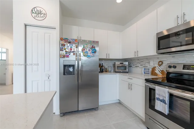 a kitchen with stainless steel appliances granite countertop a refrigerator stove and sink
