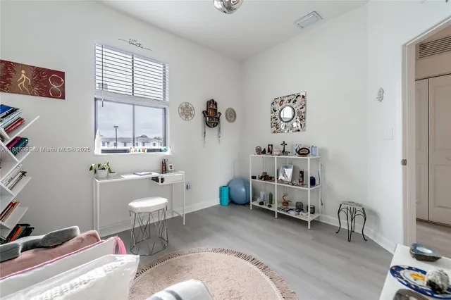 a view of a hallway with wooden floor and a bathroom