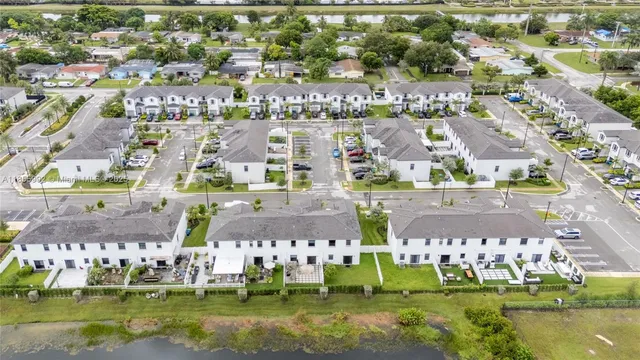 an aerial view of multiple houses with a big yard