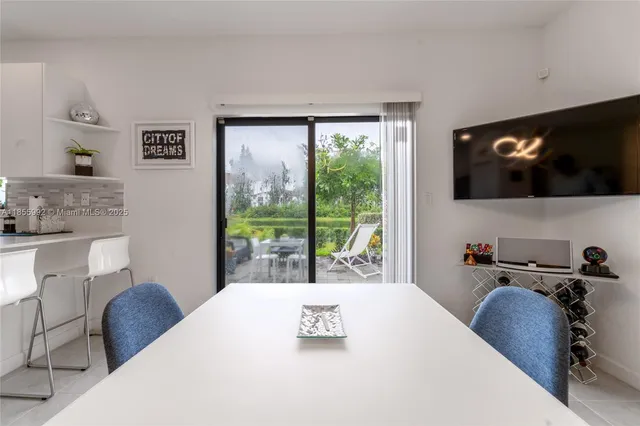 a bedroom with a bed a flat screen tv and a large window