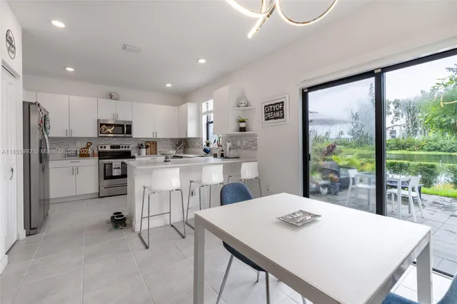 a kitchen with kitchen island a table and chairs in it