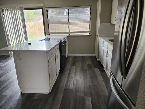 a kitchen with a sink a refrigerator and window