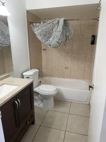 a bathroom with a granite countertop bathtub sink vanity mirror and toilet