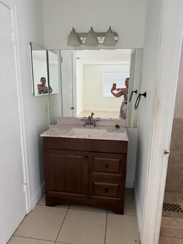 a bathroom with a sink vanity and mirror