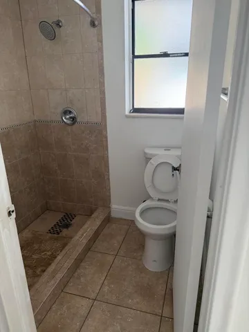 a bathroom with a toilet and a shower