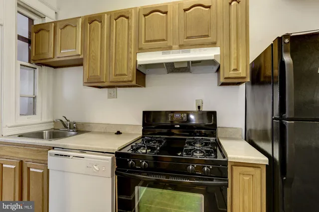 a kitchen with stainless steel appliances granite countertop a stove a refrigerator and a sink