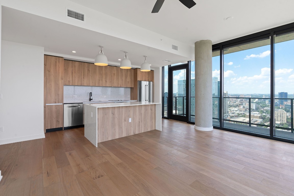 84 East Avenue, Unit 3404 Austin, TX 78701 - Photo 13 of 40 a view of a kitchen with a fridge and wooden floor