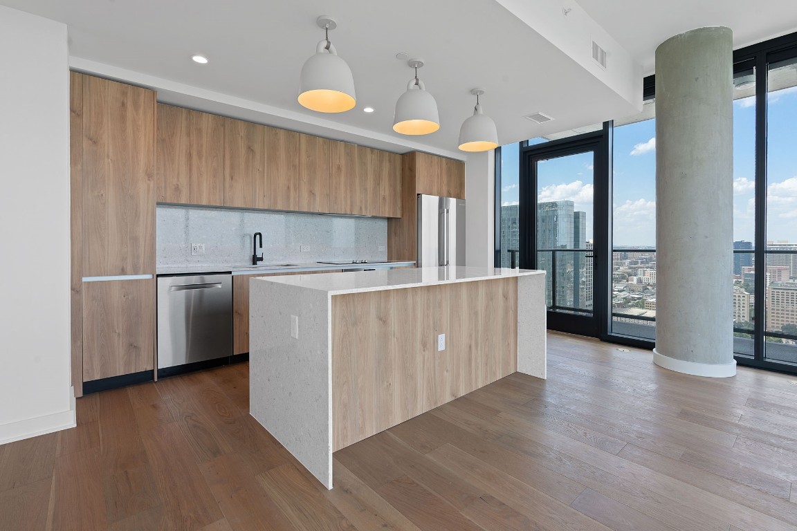 84 East Avenue, Unit 3404 Austin, TX 78701 - Photo 2 of 40 a kitchen with stainless steel appliances granite countertop a sink a refrigerator and a stove with wooden floor
