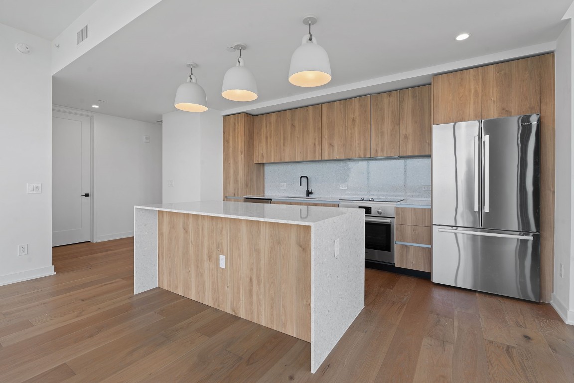 84 East Avenue, Unit 3404 Austin, TX 78701 - Photo 3 of 40 a kitchen with a refrigerator a sink and cabinets
