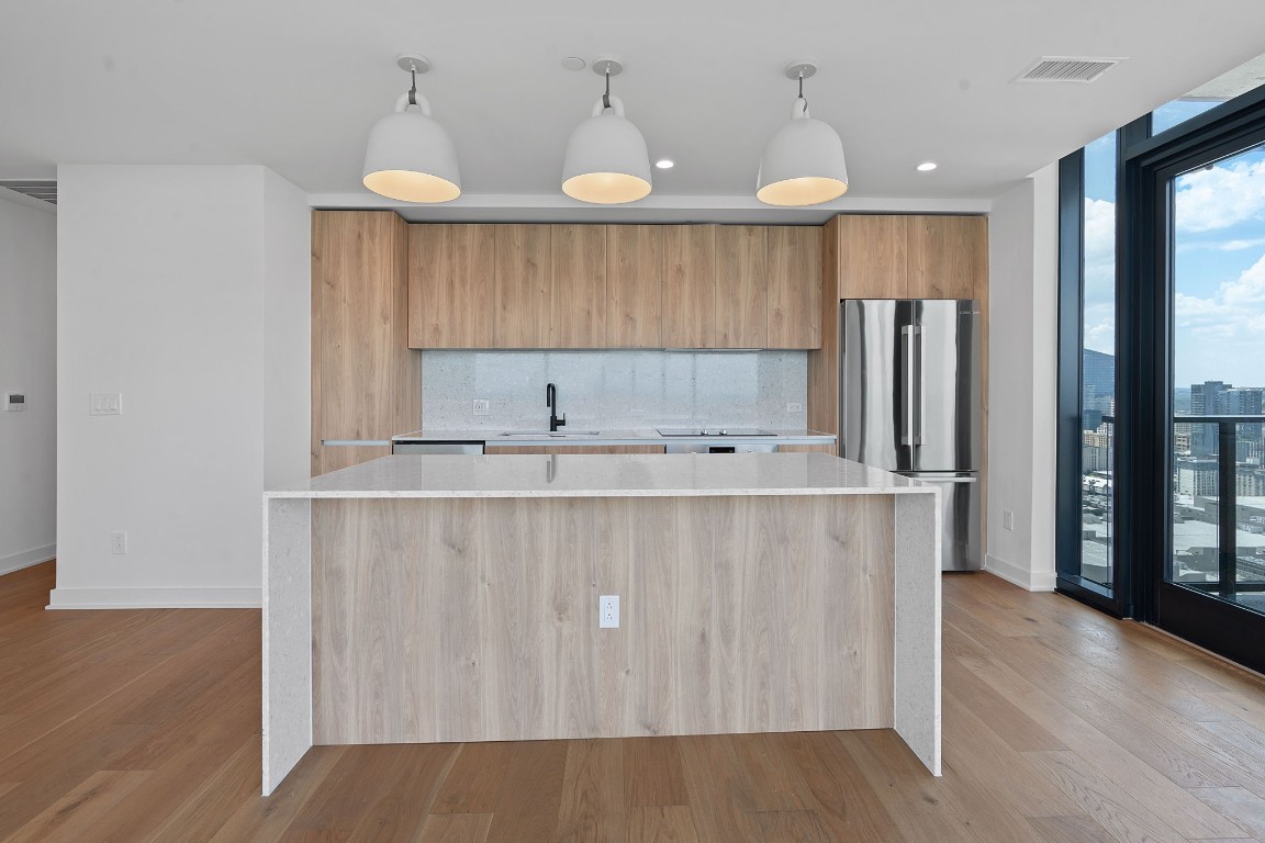 84 East Avenue, Unit 3404 Austin, TX 78701 - Photo 4 of 40 a kitchen with stainless steel appliances a sink a refrigerator and wooden floor