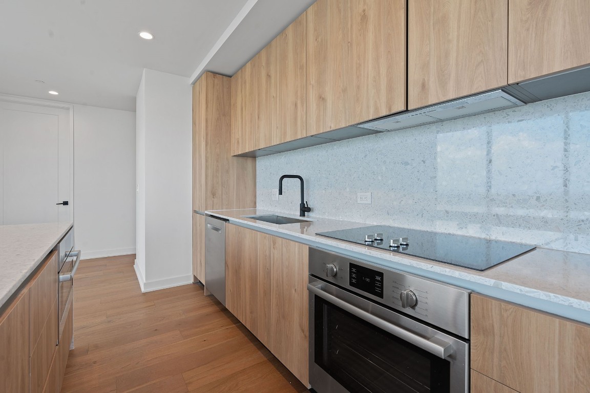 84 East Avenue, Unit 3404 Austin, TX 78701 - Photo 6 of 40 a kitchen with a sink stove and cabinets