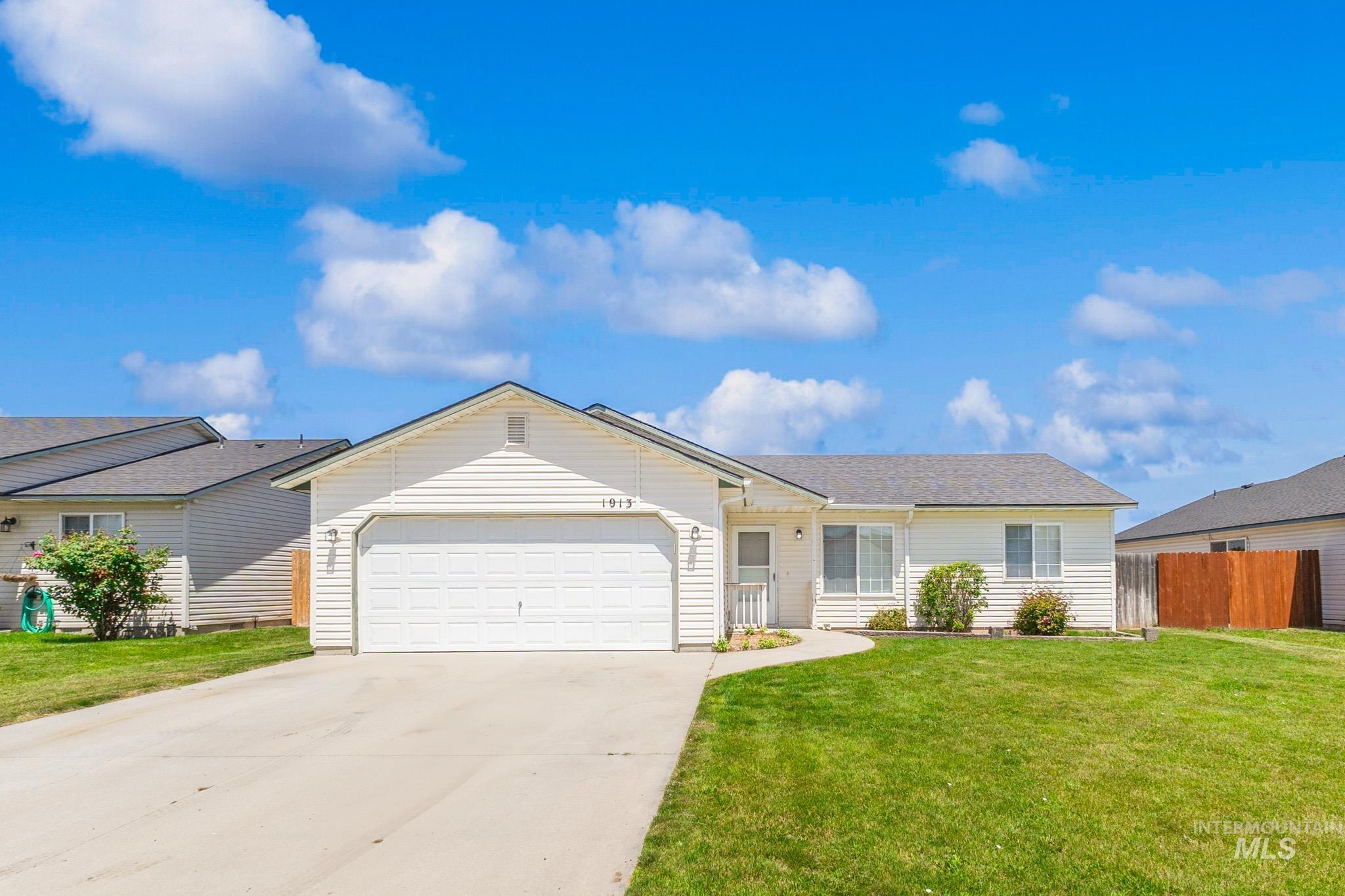 Ranch-style home featuring an attached garage and concrete driveway