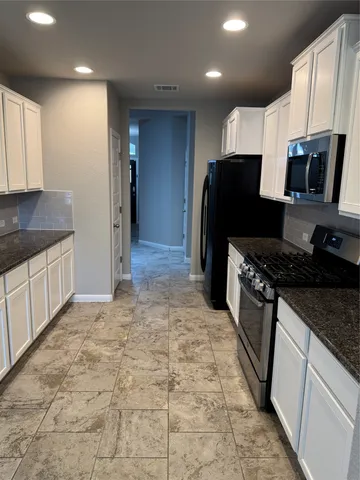 a kitchen with stainless steel appliances granite countertop a refrigerator stove and sink