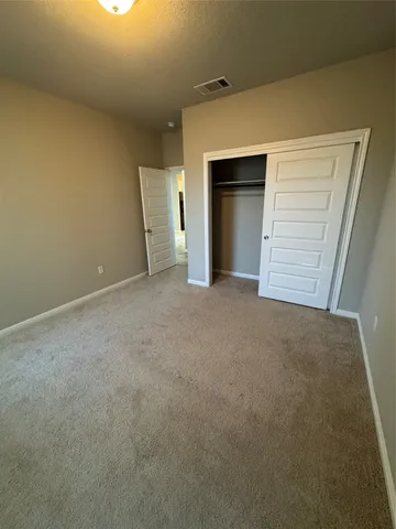 a view of an empty room with a fireplace and a window