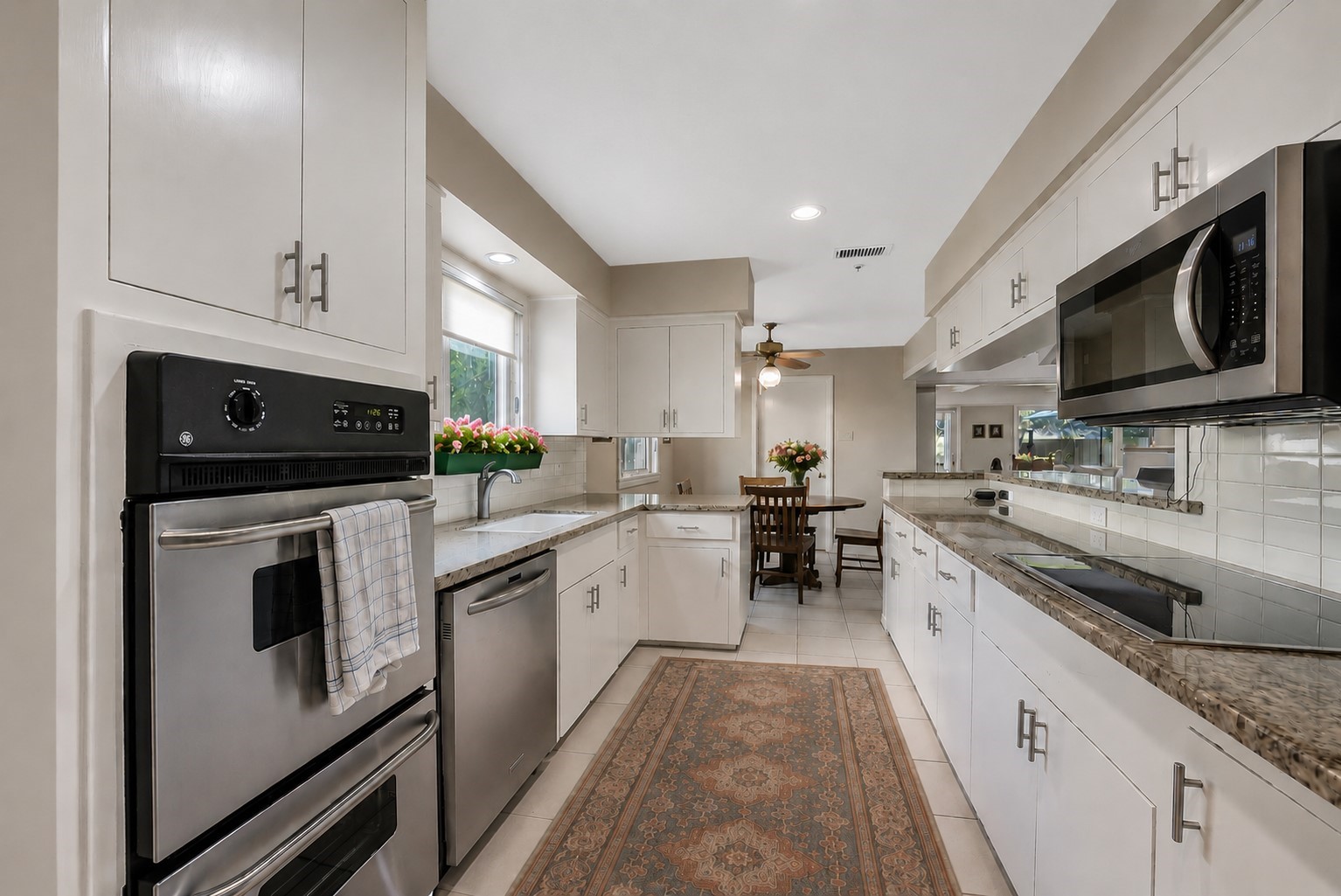 5626 Hummingbird Street Houston, TX 77096 - Photo 9 of 34 VIRTUALLY STAGED. Another view of the cheerful and light kitchen looking now toward the breakfast area. The GE stainless steel double wall ovens were installed in 2025.