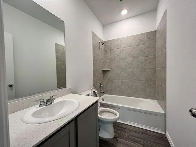 a bathroom with a granite countertop sink toilet a mirror and shower