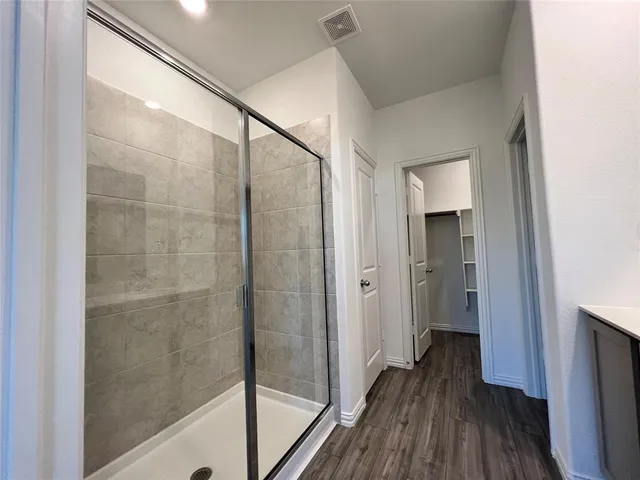 a bathroom with a shower and a glass door