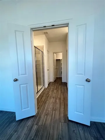a view of a hallway with wooden floor