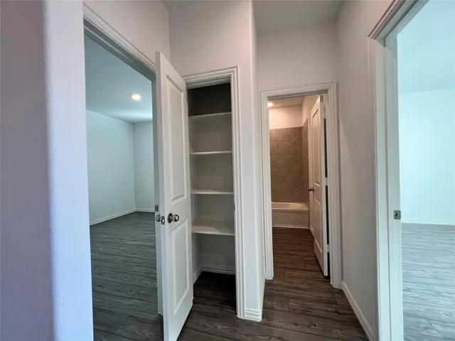 a view of a hallway with wooden floor and closet