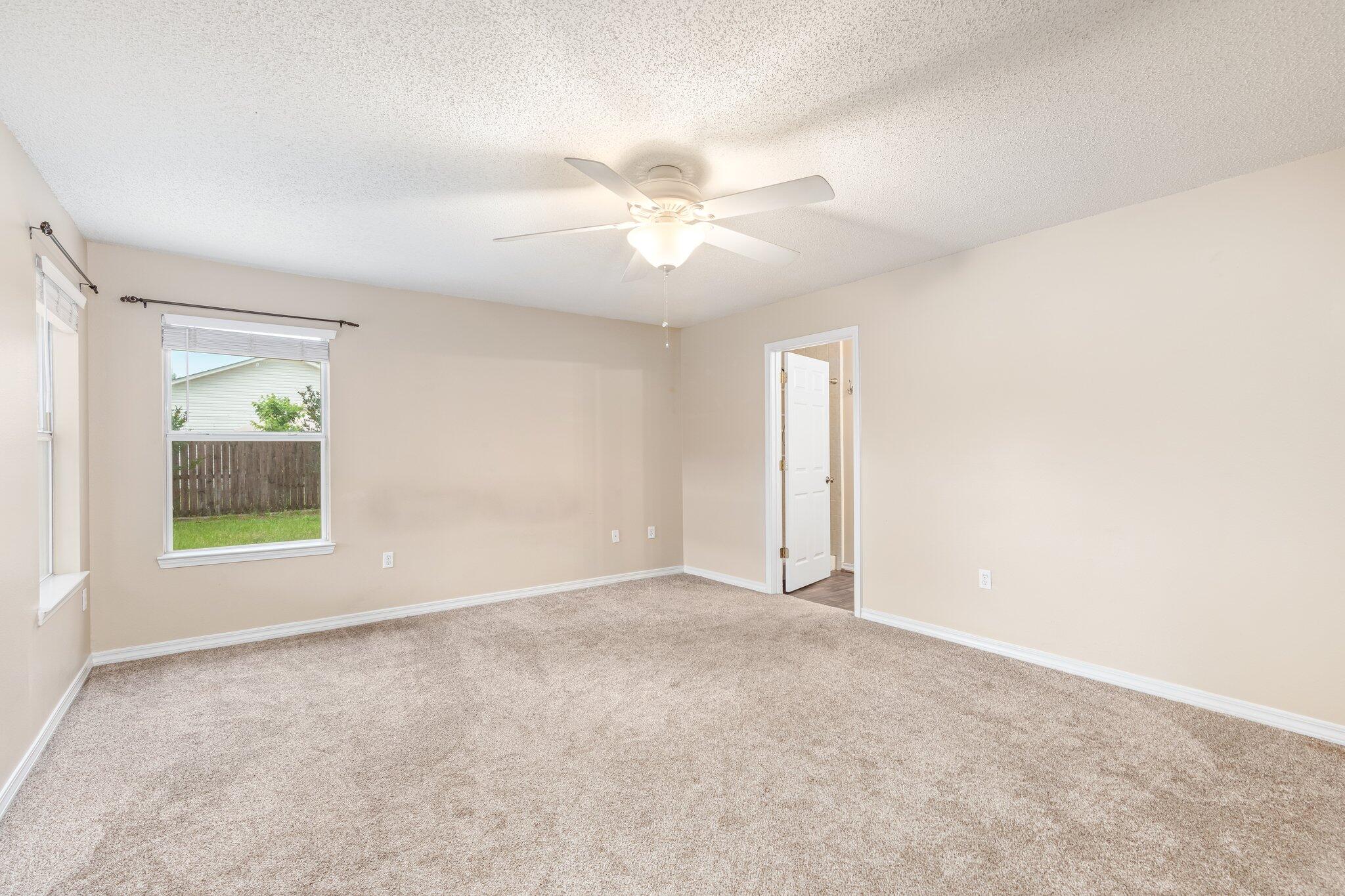 273 Limestone Circle Crestview, FL 32539 - Photo 21 of 36 an empty room with windows and a ceiling fan
