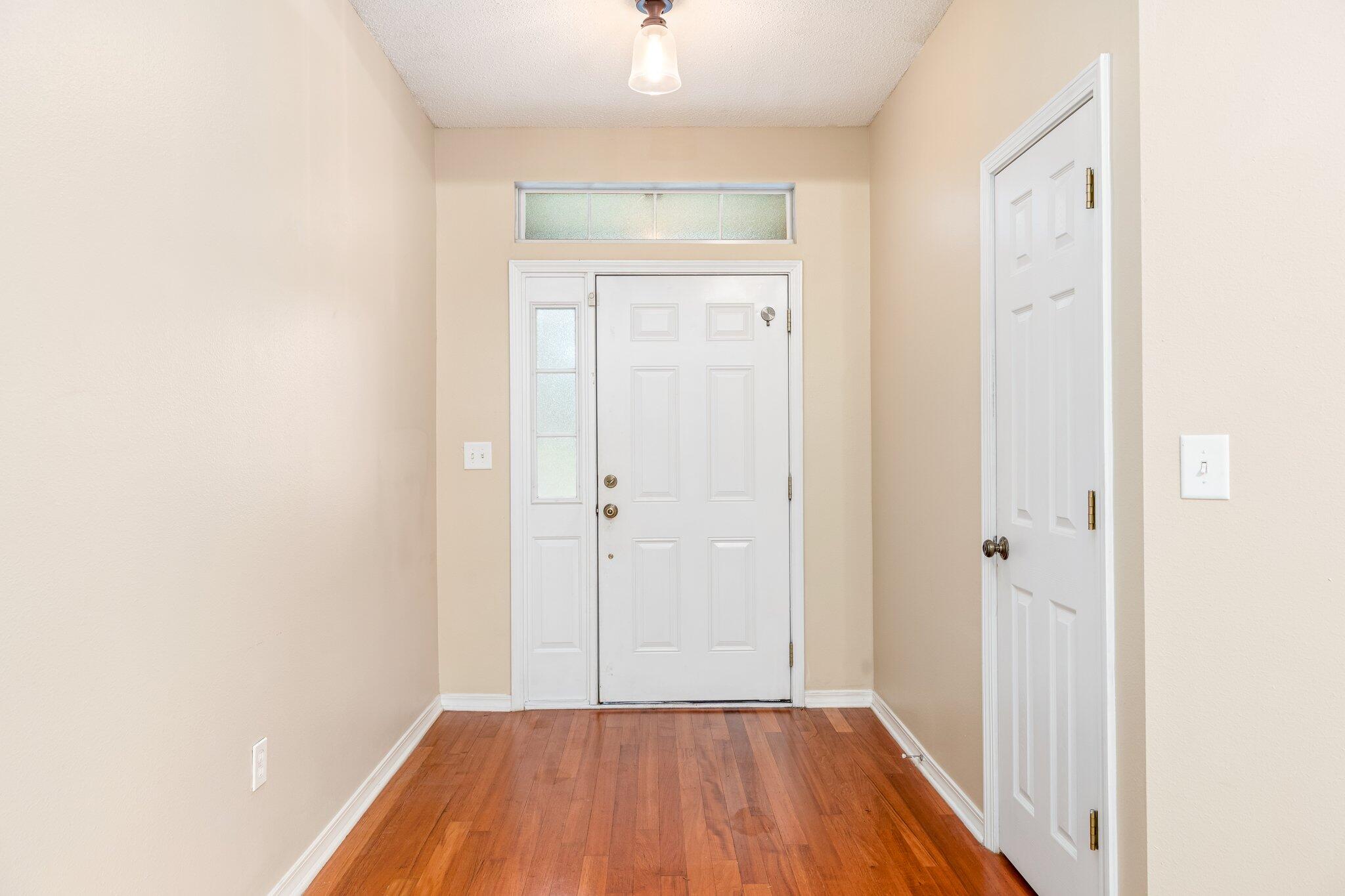 273 Limestone Circle Crestview, FL 32539 - Photo 4 of 36 a view of a hallway with wooden floor and a bathroom
